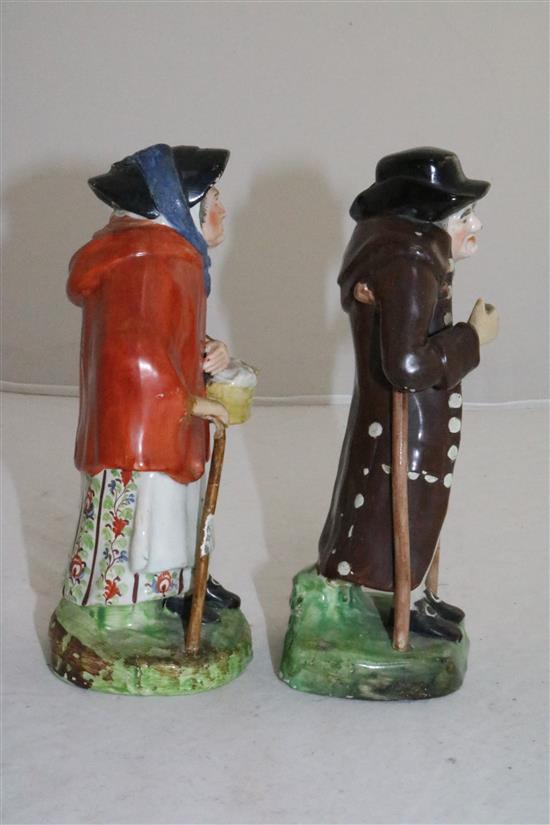 A pair of Staffordshire pearlware figures of an elderly lady and gentleman, c.1830, height 18cm (7.1in.), restorations